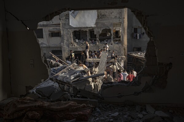 Palestinians look at the destruction after Israeli strikes on the Gaza Strip in Khan Younis, Saturday, Now. 4, 2023. (AP Photo/Fatima Shbair)