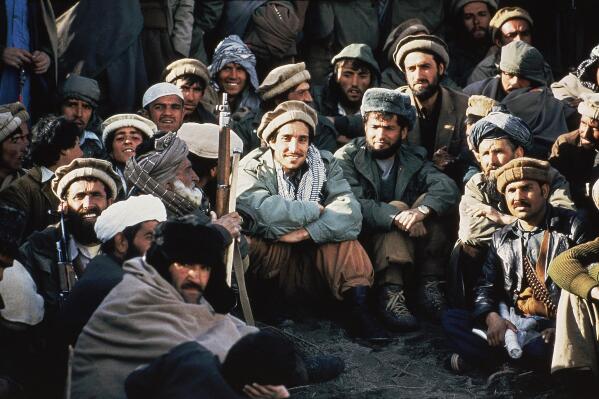 FILE - In this 1984 file photo, Afghan guerrilla leader, Ahmad Shah Massoud, center, is surrounded by Mujahideen commanders at a meeting of the rebels in the Panjshir Valley in northeast Afghanistan.  In August 2021, the last remnants of Afghanistan’s shattered security forces have vowed to resist the Taliban in the remote Panjshir Valley north of Kabul, that has defied conquerors before. Under the leadership of Massoud, fighters in the Panjshir Valley held off the Soviets in the 1980s and the Taliban a decade later. Any attempt to re-enact his exploits appears likely to fail, posing little threat to the country's new Taliban rulers. (AP Photo/Jean-Luc Bremont, File)