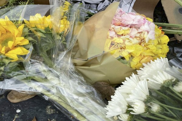 Flowers, candles and signs are displayed at a makeshift memorial on Friday, March 19, 2021, in Atlanta.  Robert Aaron Long, a white man, is accused of killing several people, most of whom were of Asian descent, at massage parlors in the Atlanta area. (AP Photo/Candice Choi)