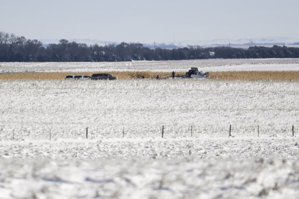 Law enforcement surveys the scene of a plane crash on Monday, Dec. 2, 2019 in Chamberlain, S.D. Nine people were killed and three people were injured when a plane crashed shortly after taking off on Saturday, Nov. 30, 2019.  (Abigail Dollins/The Argus Leader via AP)