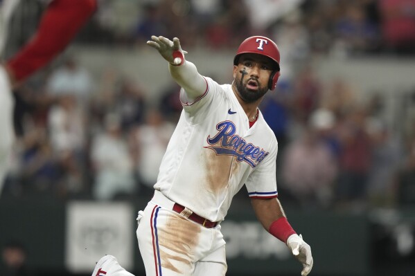 Texas Rangers Ezequiel Duran gestures towards his dugout after hitting a solo home run during the eighth inning of a baseball game against the Detroit Tigers in Arlington, Texas, Tuesday, June 27, 2023. (AP Photo/LM Otero)