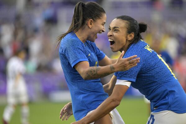 FILE - Brazil forward Debinha, left, celebrates after her goal off an assist from Marta, right, during the SheBelieves Cup women's soccer match against Japan, Thursday, Feb. 16, 2023, in Orlando, Fla. Brazil will bid to host the 2027 Women’s World Cup, the South American nation's sports ministry said Tuesday, March 7. The ministry said on Twitter that the country's bid “is being constructed by the government and sports bodies," including the Brazilian soccer confederation. (AP Photo/Phelan M. Ebenhack, file)