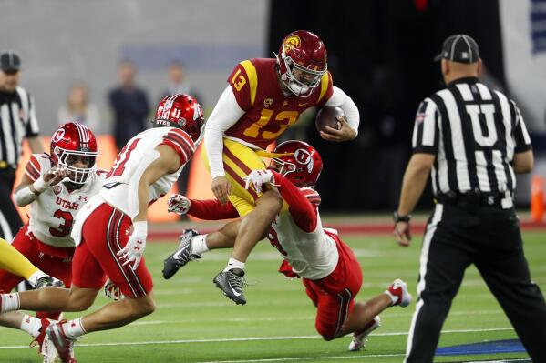 Southern California quarterback Caleb Williams (13) is tackled by Utah safeties R.J. Hubert (11) and Cole Bishop (8) during the first half of the Pac-12 Conference championship NCAA college football game Friday, Dec. 2, 2022, in Las Vegas. (AP Photo/Steve Marcus)
