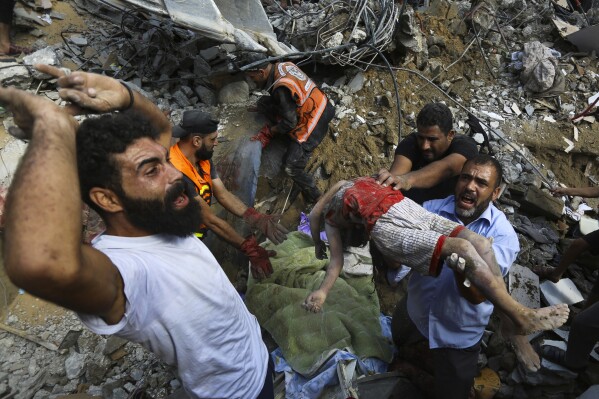 Palestinians carry the body of a dead child who was found under the rubble of a destroyed house after Israeli airstrikes on Gaza City, Tuesday, Oct. 24, 2023. (AP Photo/Abed Khaled)