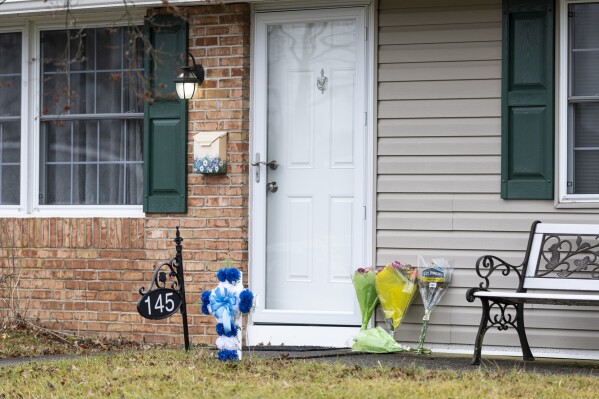 FILE - Flowers rest at the front door of the Mohn residence in Upper Orchard section in Levittown, Pa., on Friday, Feb. 2, 2024. Authorities have added more charges, including terrorism, against Justin Mohn, the Pennsylvania man charged with fatally shooting his father, decapitating him and posting a video online in which he held up the severed head. (Tyger Williams/The Philadelphia Inquirer via AP)