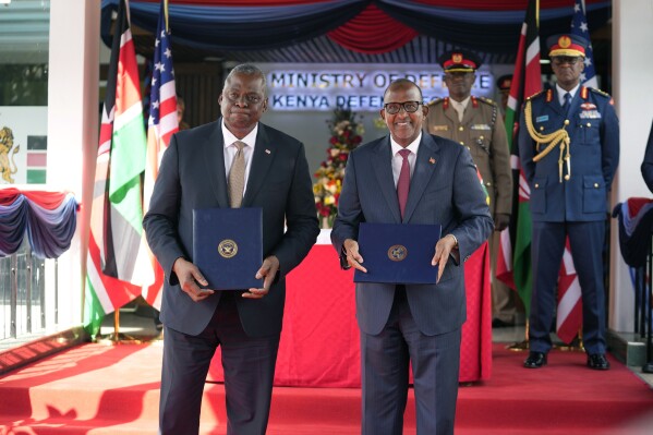 US Secretary of Defense Lloyd J. Austin, left and Kenya Cabinet Secretary for Defense Aden Duale, hold copies of a signed bilateral defense cooperation agreement, in Nairobi, Kenya, Monday Sept. 25, 2023. The U.S. and Kenya have signed a defense agreement that will see the East African nation get resources and support for security deployments as it is poised to lead a multi-national peacekeeping mission to Haiti to combat gang violence. (AP Photo/Khalil Senosi)