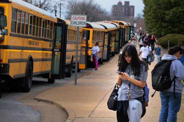 Metro High School students leave the building as a fleet of Missouri Central school busses line up to transport some after dismissal, Tuesday, Feb. 27, 2024, in St. Louis, Mo. St. Louis Public Schools said driver walkouts at Missouri Central left 56 routes uncovered Tuesday morning, and caused the school district to cancel after school activities for the second day in a row. A Black mechanic for the company that provides school bus services for the St. Louis school district said he found a noose at his workstation, leading at least 100 drivers to stop work in a show of support. (Christian Gooden/St. Louis Post-Dispatch via AP)