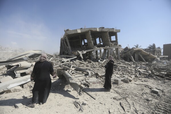Palästinenser inspizieren die Verwüstung, die durch den israelischen Luft- und Bodenangriff nach ihrem Rückzug aus Khan Yunis im südlichen Gazastreifen verursacht wurde, Sonntag, 7. April 2024. (AP Photo/Ismael Abu Dayyah)