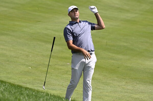 Scottie Scheffler drops his club after hitting his second shot from the rough on the first hole during the second round of the Travelers Championship golf tournament at TPC River Highlands, Friday, June 20, 2025, in Cromwell, Conn. (AP Photo/Jessica Hill)