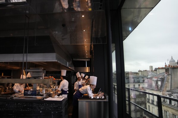 Cooks prepare food at La Tour d'Argent restaurant in Paris, Wednesday, Dec. 13, 2023. The Tour d'Argent, which claims to be the oldest restaurant in the French capital, has a front-row view of the renaissance of Notre Dame Cathedral as artisans prepare the fire-ravaged monument for reopening next year. The high-end restaurant, which helped inspire the movie 