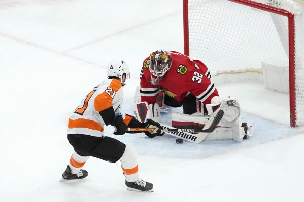 Chicago Blackhawks goaltender Kevin Lankinen (32) makes a save on a point-blank shot by Philadelphia Flyers' Scott Laughton (21) during the first period of an NHL hockey game Monday, April 25, 2022, in Chicago. (AP Photo/Charles Rex Arbogast)