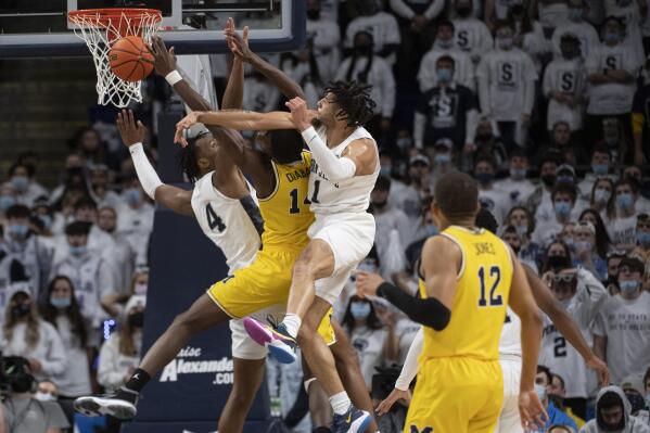 Penn State forward Seth Lundy (1) fouls Michigan forward Moussa Diabate (14) during an NCAA college basketball game Tuesday, Feb. 8, 2022 in State College, Pa. (Noah Riffe/Centre Daily Times via AP)