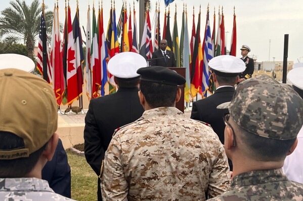Bộ trưởng Quốc phòng Hoa Kỳ Lloyd Austin, phía sau, phát biểu trước các thành viên của lực lượng đặc nhiệm hàng hải quốc tế bảo vệ các tàu thương mại ở Biển Đỏ tại trụ sở Bộ Tư lệnh Trung tâm Hải quân Hoa Kỳ ở Manama, Bahrain, Thứ Ba, ngày 19 tháng 12 năm 2023. Do các cuộc tấn công vào ngày càng gia tăng mạnh mẽ Các tàu thương mại quá cảnh ở đó trong vài tuần qua, Hoa Kỳ đã công bố một sứ mệnh mới, Chiến dịch Người bảo vệ Thịnh vượng, để kêu gọi thêm các quốc gia gửi tàu và hỗ trợ tình báo. (Ảnh AP/Tara Copp)