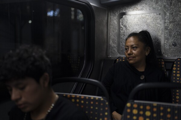 Deneffy Sánchez's mother, Lilian Lopez, rides a bus to Beverly Hills, Calif., where she cleans homes, in Los Angeles, Saturday, June 24, 2023. She's urgently trying to earn money as she searches for a better living situation. (AP Photo/Jae C. Hong)