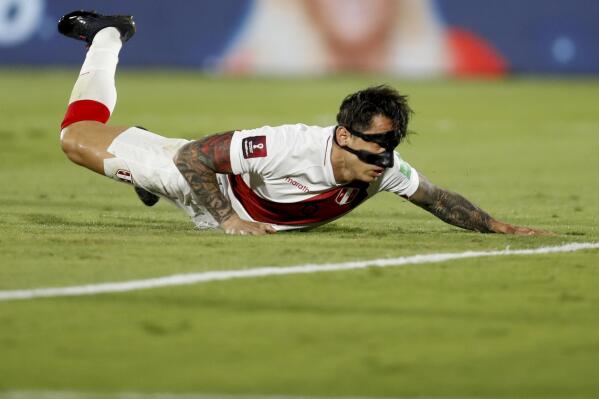 Peru's Gianluca Lapadula falls to the ground during a qualifying soccer match against Uruguay for the FIFA World Cup Qatar 2022 in Montevideo, Uruguay, Thursday, March 24, 2022. (AP Photo/Matilde Campodonico, Pool)