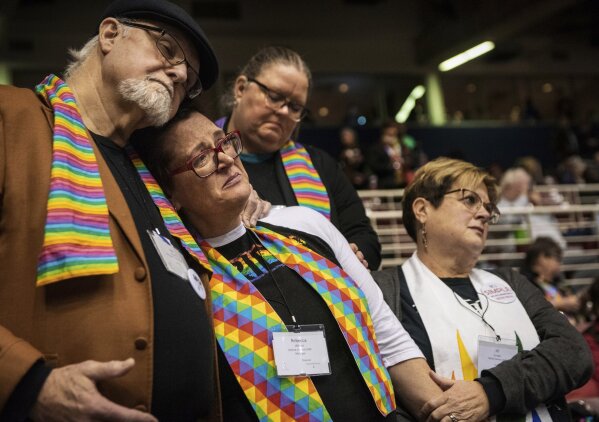 FILE - In this Feb. 26, 2019, file photo, Ed Rowe, left, Rebecca Wilson, Robin Hager and Jill Zundel, react to the defeat of a proposal that would allow LGBTQ clergy and same-sex marriage within the United Methodist Church at the denomination's 2019 Special Session of the General Conference in St. Louis, Mo. Had there been no COVID-19 coronavirus pandemic, America’s largest mainline Protestant denomination would be convening in May 2020 for a likely vote on breaking up over differences on same-sex marriage and ordination of LGBTQ pastors. (AP Photo/Sid Hastings, File)