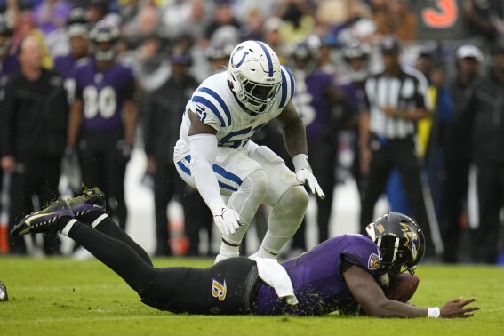 Baltimore Ravens quarterback Lamar Jackson falls on a fumble as he is tackled by Indianapolis Colts' Kwity Paye during the first half of an NFL football game, Sunday, Sept. 24, 2023, in Baltimore. (AP Photo/Julio Cortez)