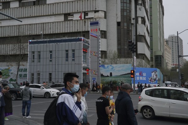 FILE - People walk past a police station in Urumqi, the capital of China's far west Xinjiang region, on April 21, 2021. A prominent Uyghur scholar specializing in the study of her people's folklore and traditions has been sentenced to life in prison, according to a U.S.-based foundation that works on human rights cases in China. Rahile Dawut was convicted on charges of endangering state security in December 2018 in a secret trial, the San Francisco-based Dui Hua Foundation said in a statement Thursday, Sept. 21, 2023. (AP Photo/Dake Kang, File)