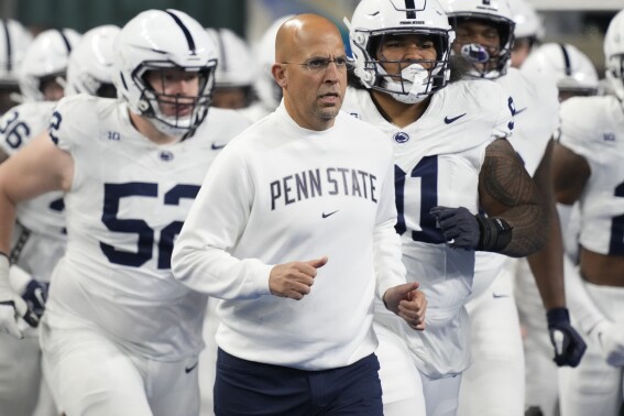 FILE - Penn State head coach James Franklin, center, runs out with his team before an NCAA college football game against Michigan State, Nov. 24, 2023, in Detroit. An internal review by Penn State in 2019 found evidence of “friction” between football coach James Franklin and a now-former team doctor. However, it could not determine whether Franklin violated NCAA rules or Big Ten standards by interfering with medical decisions. (AP Photo/Carlos Osorio, File)