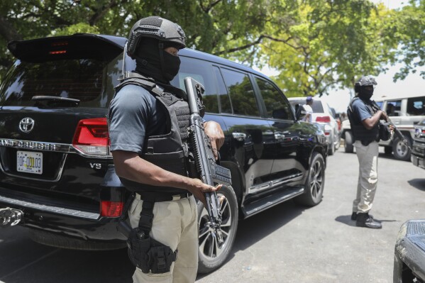 Security guards stand guard as Haiti's Prime Minister Garry Conille leaves after attending the inauguration of the nation's new cabinet in Port-au-Prince, Haiti, Wednesday, June 12, 2024. (AP Photo/Odelyn Joseph)