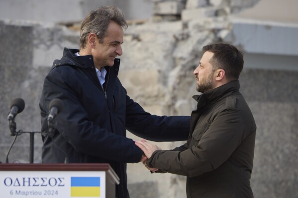 In this photo provided by the Ukrainian Presidential Press Office, Ukrainian President Volodymyr Zelenskyy, right, and Greece's Prime Minister Kyriakos Mitsotakis shake hands, in Odesa, Ukraine, Wednesday, March 6, 2024. The sound of a large explosion reverberated around the Ukrainian port of Odesa as President Volodymyr Zelenskyy and Greece's prime minister ended a tour of the war-ravaged southern city Wednesday. (Ukrainian Presidential Press Office via AP)