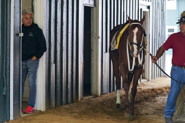 Trainer Gustavo Delgado, left, looks on as his horse Mage is walked around the stable ahead of the 148th running of the Preakness Stakes horse race at Pimlico Race Course, Wednesday, May 17, 2023, in Baltimore. (AP Photo/Julio Cortez)