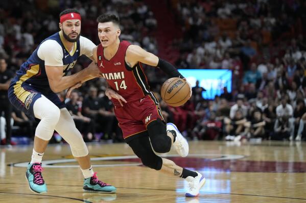 Miami Heat guard Tyler Herro (14) drives to the basket against New Orleans Pelicans forward Larry Nance Jr. during the first half of an NBA basketball game, Sunday, Jan. 22, 2023, in Miami. (AP Photo/Wilfredo Lee)