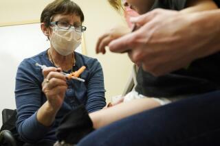 Deborah Sampson, left, a nurse at a University of Washington Medical Center clinic in Seattle, gives a Pfizer COVID-19 vaccine shot to a 20-month-old child, June 21, 2022, in Seattle. Pfizer is asking U.S. regulators to authorize its updated COVID-19 vaccine for children under age 5. The youngest tots already are supposed to get three extra-small doses of the original vaccine as their primary series. Pfizer and its partner BioNTech said Monday, Dec. 5, 2022 that if the Food and Drug Administration agrees, the updated vaccine would be used for the third shot. The FDA already has cleared COVID-19 vaccines tweaked to better target omicron as boosters for everyone 5 and older. (AP Photo/Ted S. Warren, file)