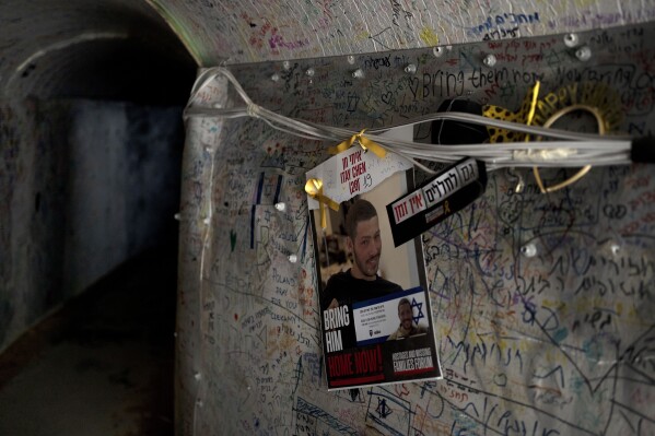 Ein Plakat mit dem Bild des getöteten israelischen Soldaten Itai Chen hängt am Mittwoch, den 8. Mai 2024, in einer Tunnelanlage im Gazastreifen in Tel Aviv. Itai wurde bei einem Hamas-Angriff am 7. Oktober getötet, aber im Gegensatz zu Dutzenden anderen Familien von Soldaten wurde dieser getötet Am selben Tag kann Chens Familie kein Grab besuchen, da die sterblichen Überreste ihres Sohnes in Gaza festgehalten werden.  Das Fehlen einer letzten Ruhestätte ist jetzt deutlich zu spüren, da Israel den Gedenktag für gefallene Soldaten begeht und die Friedhöfe voller Angehörige sind, die über den Gräbern ihrer Lieben weinen.  (AP Photo/Maya Aleruso)