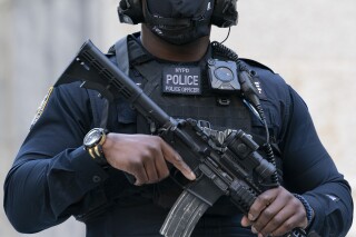 FILE - A New York Police Department's counterterrorism officer wearing a video camera, stands outside St. Patrick's Cathedral wearing a body camera in New York on Oct. 5, 2020. Body cameras have proliferated in law enforcement agencies in the U.S. over the past decade, amid mounting scrutiny over how officers and agents interact with the communities they serve. They're forcing major changes in how policing is done, even as research is mixed on their effectiveness. (AP Photo/Mark Lennihan, File)