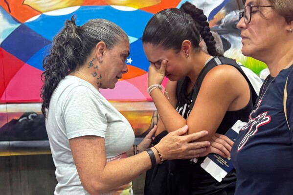 University student Ivanna De Gregorio cries as she says goodbye to her mother Irene De Gregorio before boarding a flight at Simon Bolivar International Airport in Maiquetia, Venezuela, Friday, June 6, 2025. De Gregorio, who studies at a Mississippi school on a tennis scholarship, decided to end her summer break with family in Venezuela in order to be in the U.S. before travel restrictions go into effect for Venezuelans. (AP Photo/Juan Arraez)