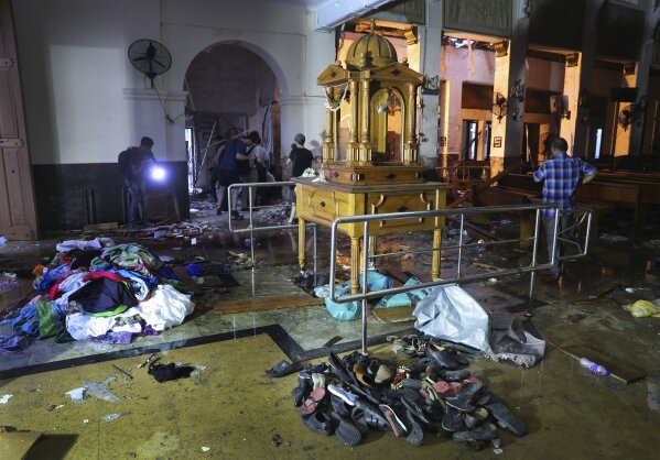 
              Shoes and other belongings left by panicked worshippers are seen stacked up inside St. Anthony's Church in Colombo, Sri Lanka, Friday, April 26, 2019. Priests have allowed journalists inside St. Anthony's Church in Sri Lanka for the first time since it was targeted in a series of Islamic State-claimed suicide bombings that killed over 250 people. Broken glass littered the sanctuary's damaged pews and blood stained the floor. Shoes left by panicked worshippers remained in the darkened church, and broken bottles of holy water lay on the floor. (AP Photo/Manish Swarup)
            