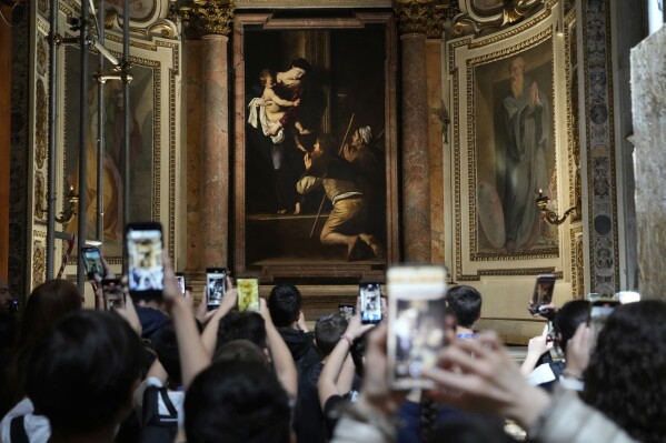 Tourists admire the Pilgrims' Madonna, of Caravaggio is seen at the Basilica of St. Augustine in Rome, Thursday, May 22, 2025. (AP Photo/Gregorio Borgia)