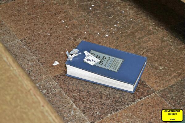 This photo of bullet-damaged prayer book in the Tree of Life synagogue building in Pittsburgh was entered May 30, 2023, as a court exhibit by prosecutors in the federal trial of Robert Bowers. He faces multiple charges in the killing of 11 worshippers from three congregations and the wounding of seven worshippers and police officers in the building on Oct. 27, 2018. The charges include the obstruction of the free exercise of religion, resulting in death. (U.S. District Court for the Western District of Pennsylvania via AP)