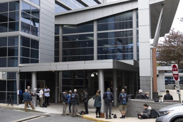 Members of the media gather outside the justice center in Wilmington, Del., Monday, April 17, 2023. The Delaware judge overseeing Dominion Voting Systems' defamation lawsuit against Fox News announced a delay in the start of the trial until Tuesday, giving no explanation in announcing the recess. (AP Photo/Matt Rourke)