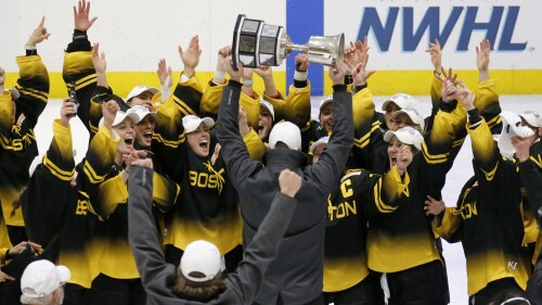 FILE - Boston Pride players cheer as coach Paul Mara hoists the NWHL Isobel Cup trophy after the team's win over the Minnesota Whitecaps in the championship hockey game in Boston, Saturday, March 27, 2021. Organizers announced plans Friday, June 30, 2023, to launch a new women’s professional hockey league in January that they hope will provide a stable, economically sustainable home for the sport's top players for years to come. The agreement ends a long standoff between the seven-team Professional Hockey Federation (PHF) and the PWHPA. (AP Photo/Mary Schwalm, File)