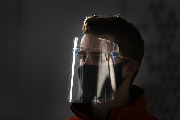 In this Dec. 16, 2020, photo, A hosts directs visitors of a COVID-19 testing facility of the Municipal Health Authority GGD, in Utrecht, Netherlands. The Netherlands is banning flights from the United Kingdom for the rest of the year in an attempt to make sure that a new strain of the COVID-19 virus in Britain does not reach its shores. The ban came into effect Sunday morning Dec. 20, 2020, and the government said it was reacting to tougher measures imposed in and around London on Saturday. The Netherlands said it will assess "with other EU nations the possibilities to contain the import of the virus from the United Kingdom." (AP Photo/Peter Dejong)