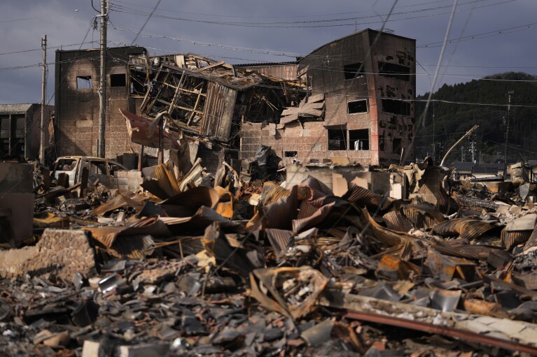 Burned-out vehicles and other debris are seen after a fire near the Asaichi-dori shopping street in Wajima in the Noto peninsula, facing the Sea of Japan, northwest of Tokyo on Jan. 5, 2024, following a deadly earthquake on New Year's Day. (AP Photo/Hiro Komae)