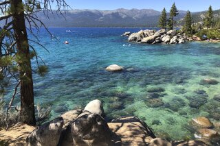 This photo taken July 13, 2020 at Lake Tahoe Nevada State Park shows a stretch of the lake's northeast shore looking north from Sand Harbor toward Incline Village, Nev.  Lake Tahoe's fluctuating clarity took a dive last year, worsening by about 8 feet during an especially cold and wet winter as sedimentation, algae growth and a tiny invasive shrimp continue to pose restoration challenges. (AP Photo/Scott Sonner).