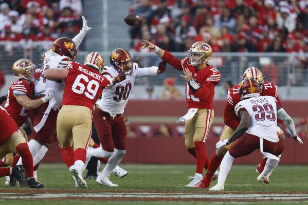San Francisco 49ers quarterback Brock Purdy (13) throws to a receiver as he is pressured by Washington Commanders defensive end Montez Sweat (90) in the second half of an NFL football game, Saturday, Dec. 24, 2022, in Santa Clara, Calif. (AP Photo/Jed Jacobsohn)