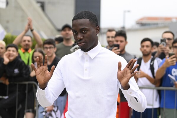 US soccer player Timothy Weah, front, waves as he arrives for fitness tests at the Italian soccer club Juventus F.C. in Turin, Italy, Thursday, June 29, 2023. (Fabio Ferrari/LaPresse via AP)