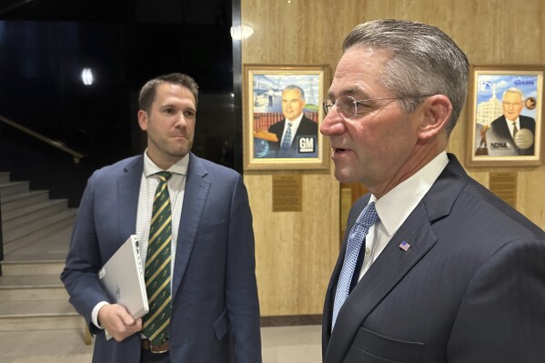 FILE - North Dakota Secretary of State Michael Howe, left, and Attorney General Drew Wrigley, right, converse with State Treasurer Thomas Beadle, unseen, before a meeting at the state Capitol, Sept. 29, 2023, in Bismarck, N.D. North Dakota's top election official plans to appeal a federal judge's ruling that found the state's 2021 redistricting map violated the Voting Rights Act for two Native American tribes, just the day after a consequential ruling on the landmark federal law. Howe announced the intended appeal on Tuesday, Nov. 21. (AP Photo/Jack Dura, File)