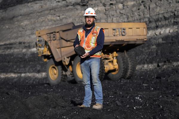 Sean Hovorka, a production superintendent at Trapper Mining, looks on as coal is hauled from the mine Thursday, Nov. 18, 2021, in Craig, Colo. Hovorka, also recently elected member of the town's city council, sees a future in mining because of renewables. (AP Photo/Rick Bowmer)