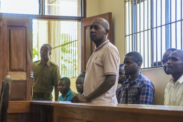 FILE - Pastor Paul Mackenzie, who was arrested on suspicion of telling his followers to fast to death in order to meet Jesus, accompanied by some of his followers, appears at a court in Malindi, Kenya on Monday, April 17, 2023. Kenya’s top prosecutor on Tuesday ordered that 95 people from a doomsday cult be charged with murder, cruelty, child torture and other crimes in the deaths of 429 people believed to be members of the church. (AP Photo, File)