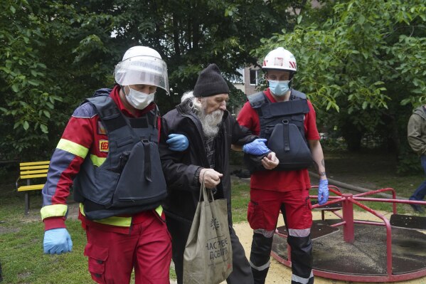 An elderly man is assisted after a Russian attack that hit a residential building in Kharkiv, Ukraine, Saturday, June 7, 2025. (AP Photo/Andrii Marienko)