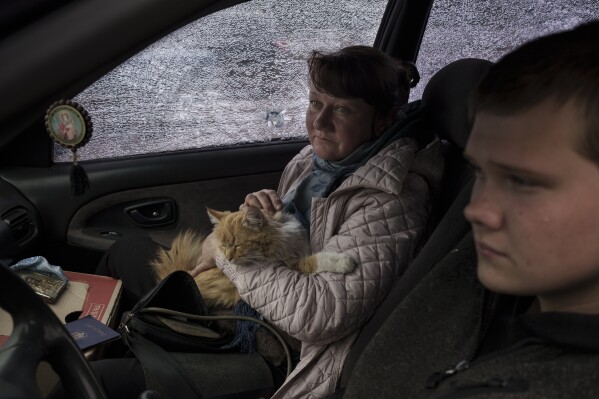 A family fleeing the village of Ruska Lozova arrive in their shrapnel-ridden car to a screening point in Kharkiv, Ukraine, Friday, April 29, 2022. (AP Photo/Felipe Dana)