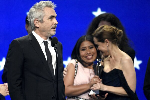 
              Alfonso Cuaron, from left, accepts the award for best picture for "Roma" as Yalitza Aparicio and Marina De Tavira react at the 24th annual Critics' Choice Awards on Sunday, Jan. 13, ...