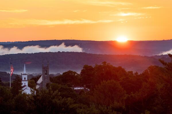 The sun rises over Newtown, Conn., Thursday, Aug. 18, 2022. Now on the cusp of adulthood, the survivors of Sandy Hook are telling their stories, some for the first time, about growing up as a mass shooting survivor to help the children in Texas, who return to school this week.(AP Photo/Julia Nikhinson).