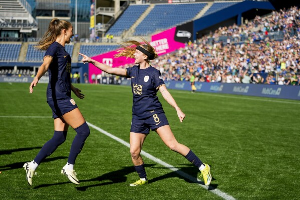 Seattle Reign forward Bethany Balcer, right, points at teammate Jordyn Huitema after scoring on a penalty kick won by Huitema against the Washington Spirit during the first half of an NWSL soccer match Sunday, March 17, 2024, in Seattle. (AP Photo/Lindsey Wasson)