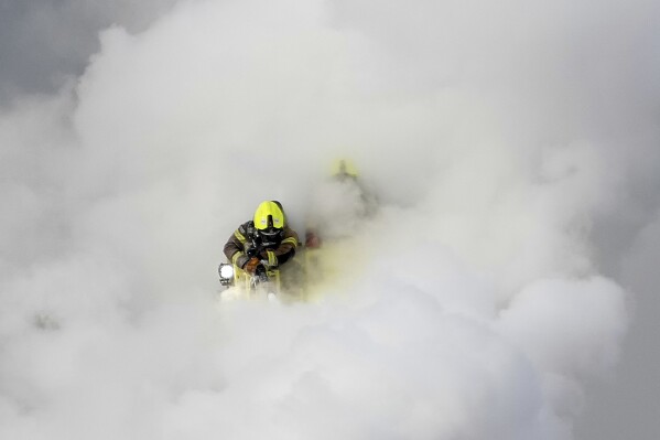 Firefighters extinguish the fire at the North Hyde electrical substation, which caught fire Thursday night and led to a closure of Heathrow Airport in London, Friday, March 21, 2025.(AP Photo/Kirsty Wigglesworth)